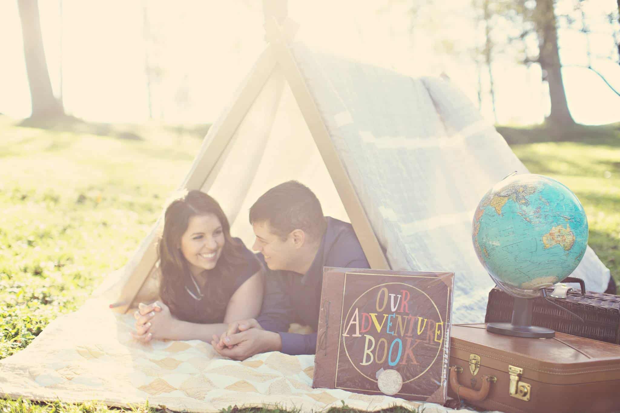 couple lying on a blanker under a classic triangle tent