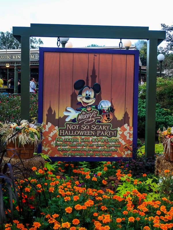 Mickey's Not So Scary Halloween Party Sign hanging in a orange flower garden at Walt Disney World