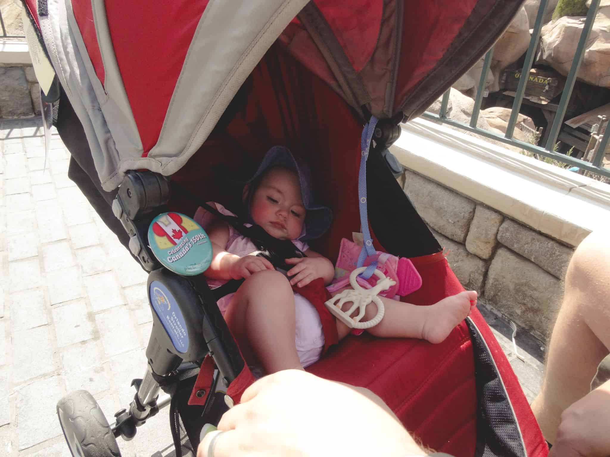 6 month old baby in red stroller at Walt Disney World