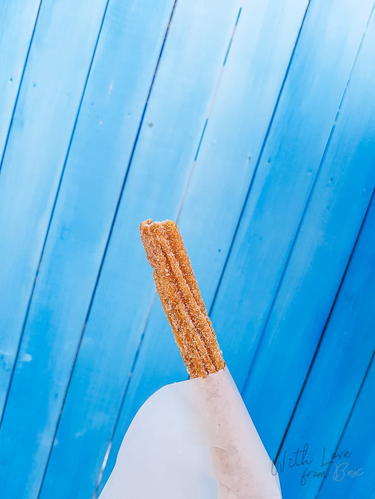 churro held up against a light blue wood background