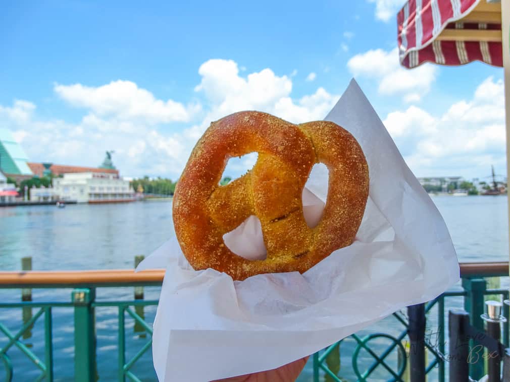 sweet cream cheese pretzel held up by the water at the Boardwalk Resort at Walt Disney World 
