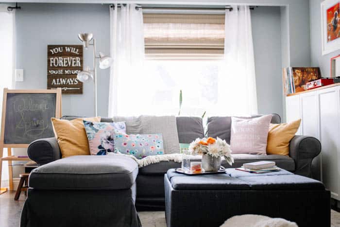 Bright living room with spring coloured pillows and flowers, of pinks and yellows